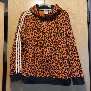 Adidas Originals x Rich Mnisi Large all over leopard print hoodie in orange.